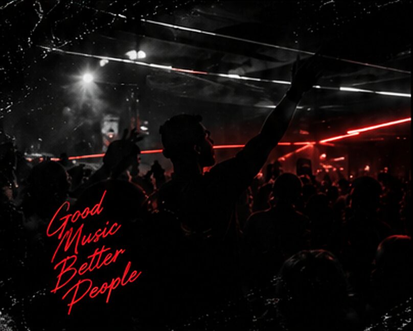 A packed Friday Frequency crowd under red lights, hands in the air